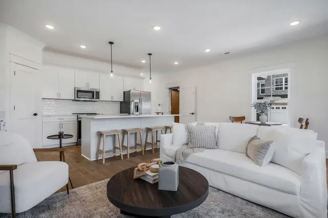 a living room with furniture and a view of kitchen