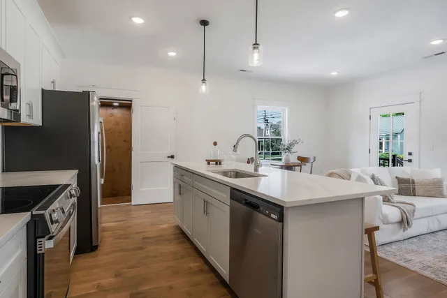 a kitchen with kitchen island a sink stove and refrigerator