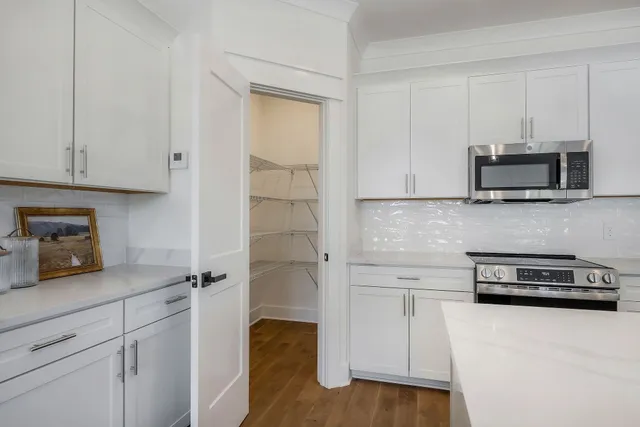 a kitchen with stainless steel appliances white cabinets and a refrigerator
