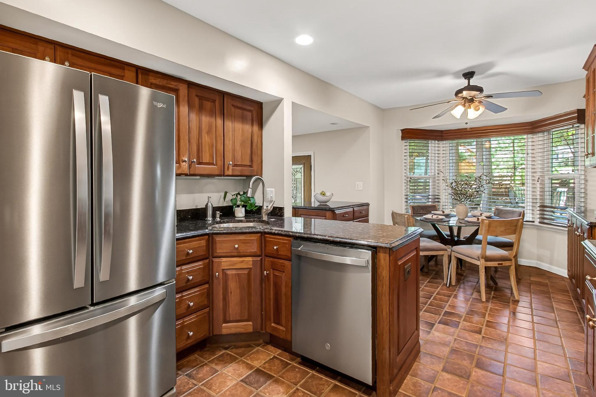 15117 Philip Lee Road Chantilly, VA 20151 - Photo 18 of 80 a kitchen with stainless steel appliances granite countertop a refrigerator a sink dishwasher a stove and a dining table with wooden floor