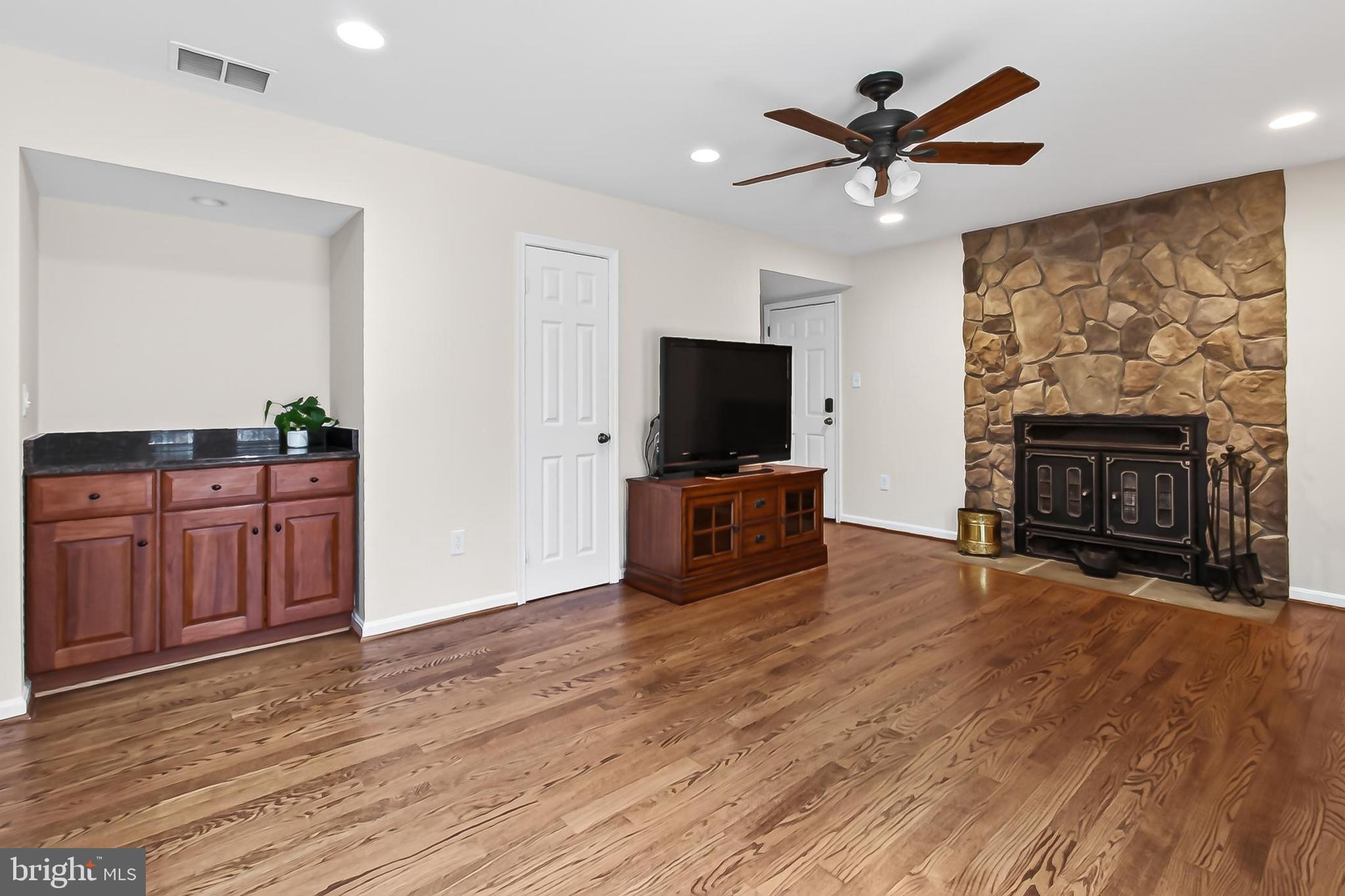 15117 Philip Lee Road Chantilly, VA 20151 - Photo 27 of 71 a living room with furniture a fireplace and a flat screen tv