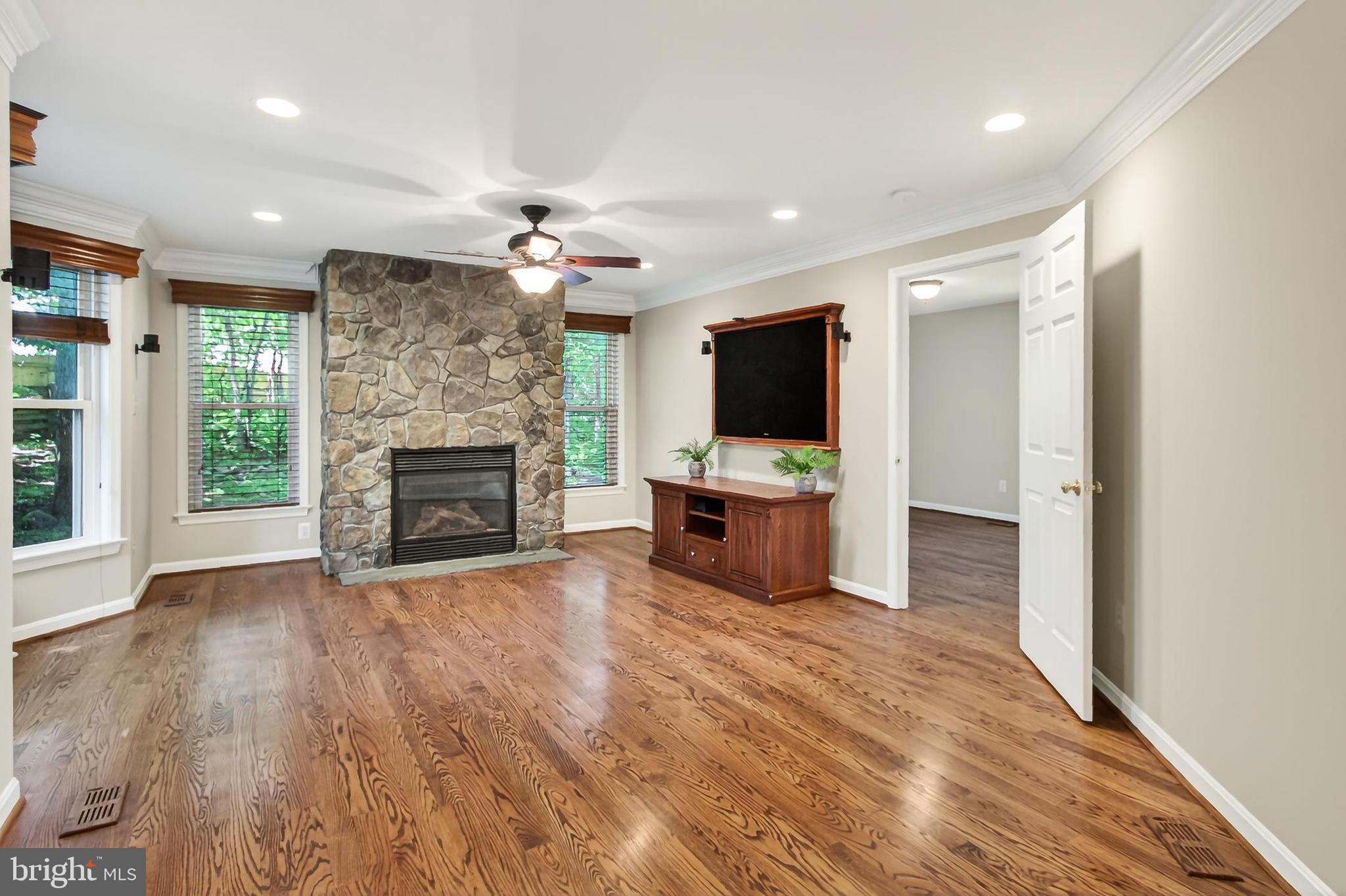 15117 Philip Lee Road Chantilly, VA 20151 - Photo 31 of 80 a view of a livingroom with a fireplace a ceiling fan and wooden floor
