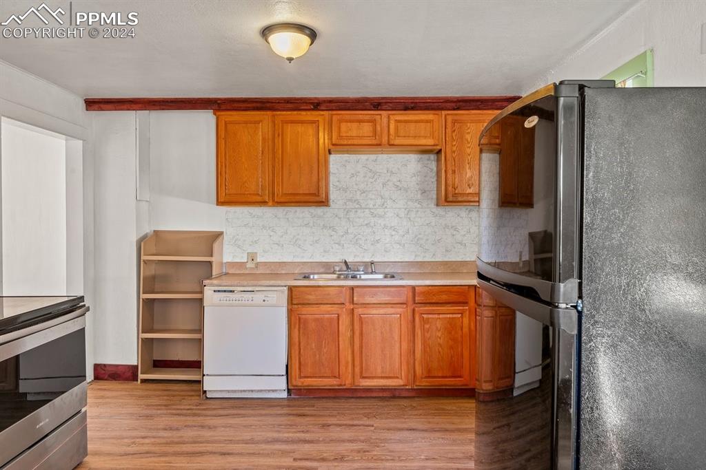 621 Edison Avenue La Junta, CO 81050 - Photo 14 of 30 a kitchen with stainless steel appliances granite countertop a refrigerator and a stove top oven