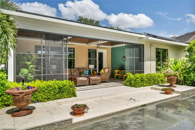 a view of a house with potted plants and a fountain