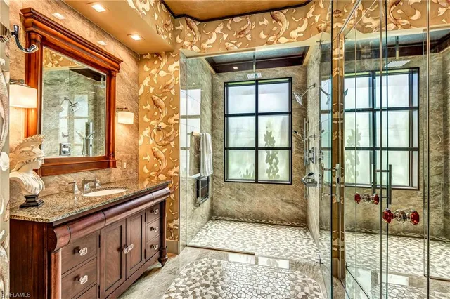 a bathroom with a granite countertop sink a mirror and next to a window