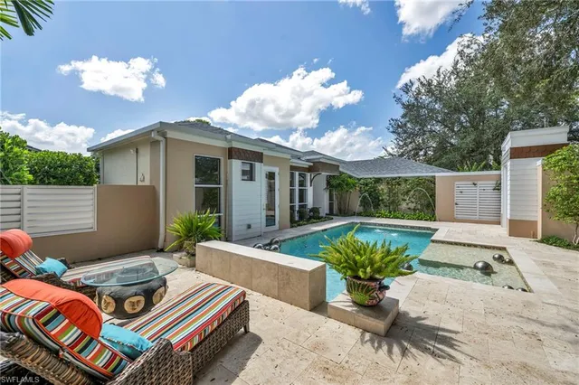 a backyard of a house with fountain table and chairs
