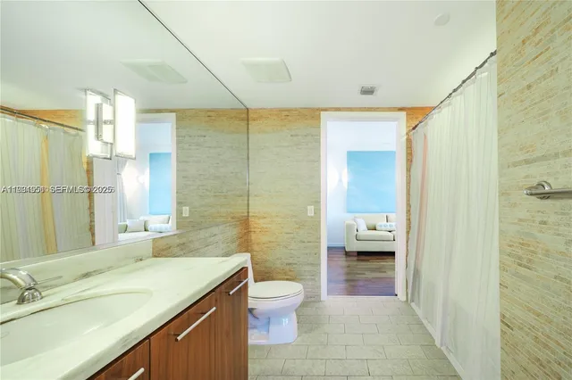 a bathroom with a granite countertop sink toilet a shower and a mirror