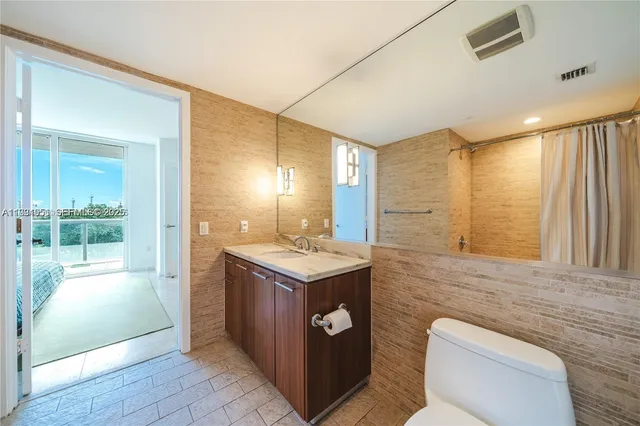 a bathroom with a toilet a sink and a mirror