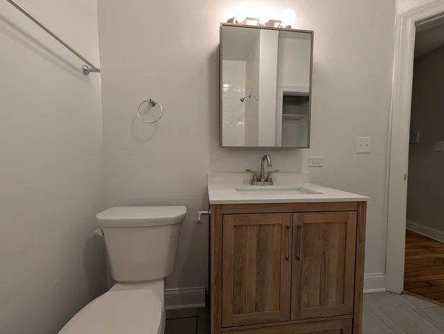 a bathroom with a toilet a sink and mirror