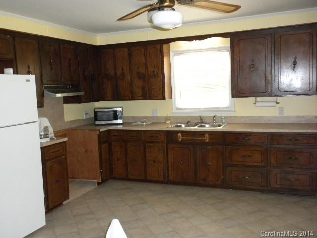 6918 Medlin Road Monroe, NC 28112 - Photo 5 of 11 a kitchen with a sink a stove a refrigerator and cabinets