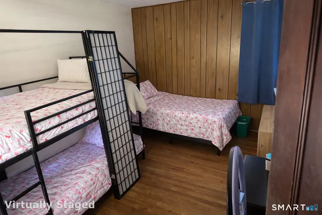 a bedroom with a bed and wooden floor