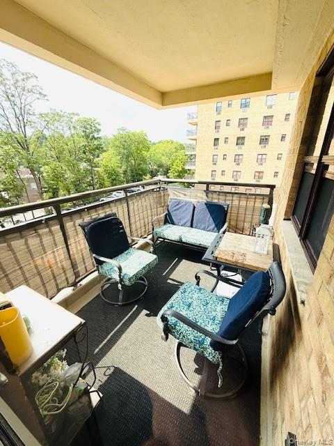 a living room with patio furniture and a floor to ceiling window