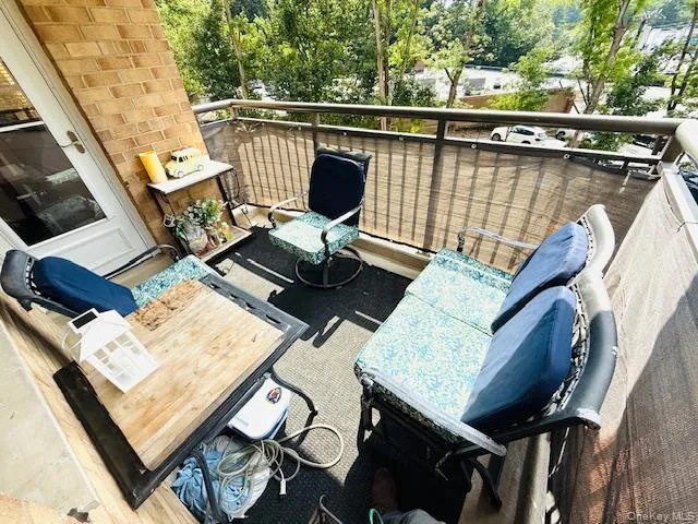 a balcony with wooden floor table and chairs