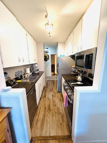 a kitchen with granite countertop a sink a counter top space appliances and cabinets