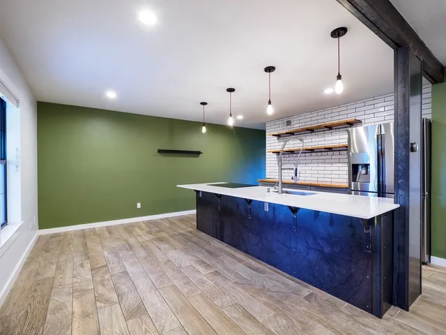 a kitchen with stainless steel appliances kitchen island a cabinets and a wooden floor
