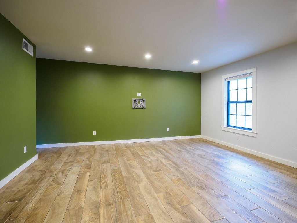 2302 East Side Drive, Unit 28 Austin, TX 78704 - Photo 7 of 16 an empty room with wooden floor and windows