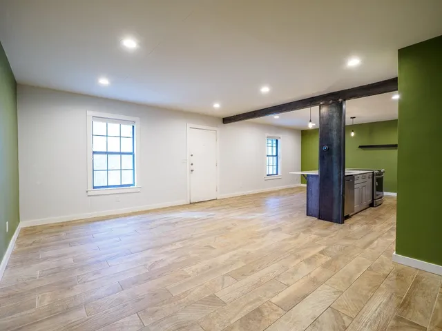 a view of an empty room with glass door and balcony