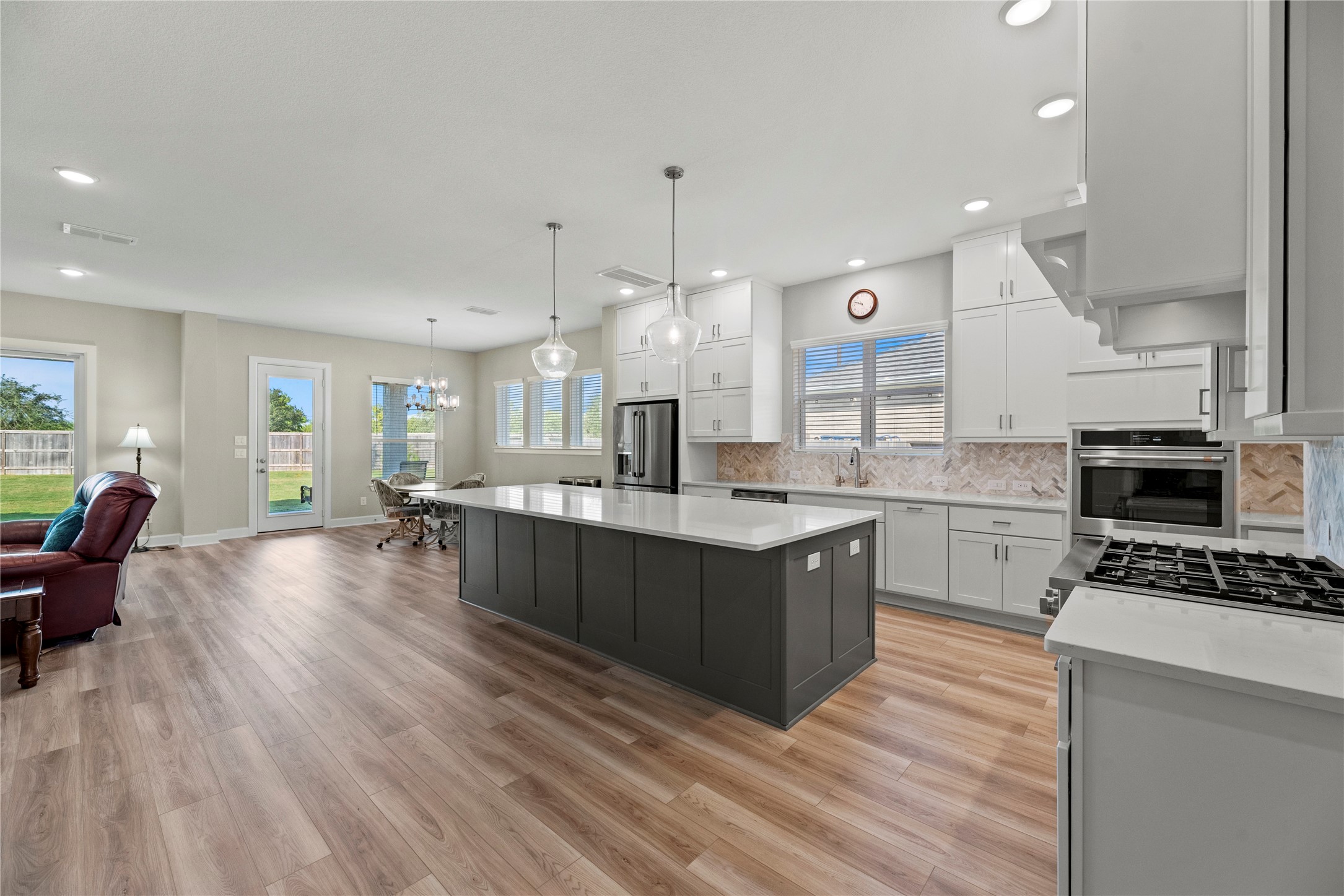 3111 Swift Way Katy, TX 77493 - Photo 22 of 50 a large kitchen with stainless steel appliances kitchen island granite countertop a stove a sink dishwasher and a microwave with wooden floor