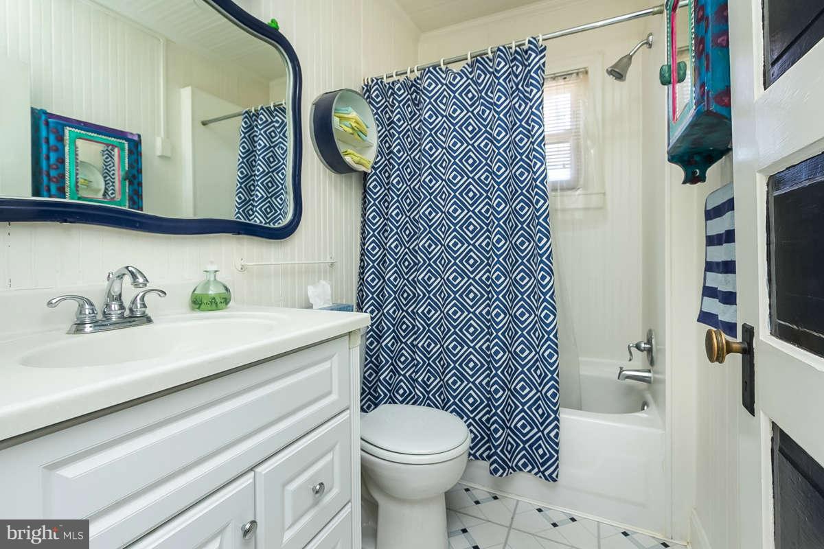 4604 Schenley Road Baltimore, MD 21210 - Photo 12 of 30 a bathroom with a sink a toilet and shower curtain