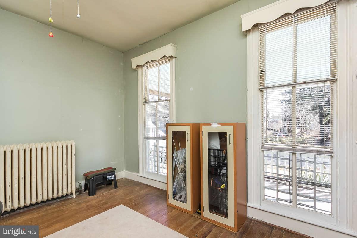 4604 Schenley Road Baltimore, MD 21210 - Photo 13 of 30 a view of a bedroom with wooden floor and a window