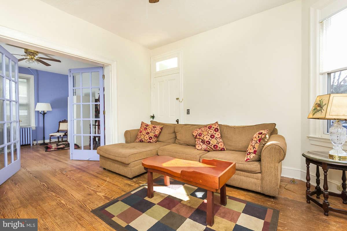 4604 Schenley Road Baltimore, MD 21210 - Photo 5 of 30 a living room with a couch and a dresser next to a window