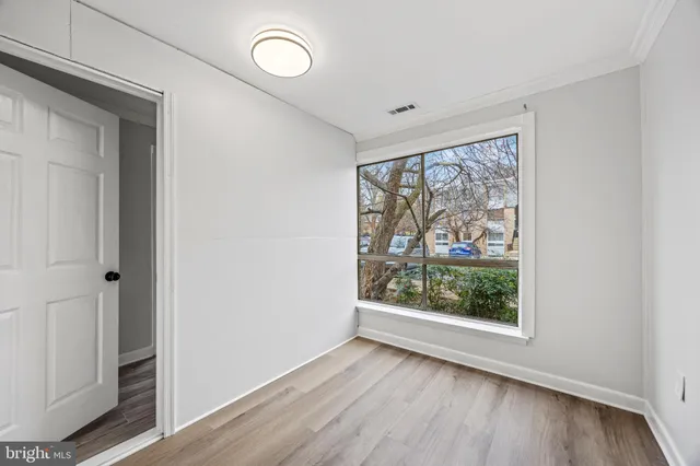 a view of an empty room with wooden floor