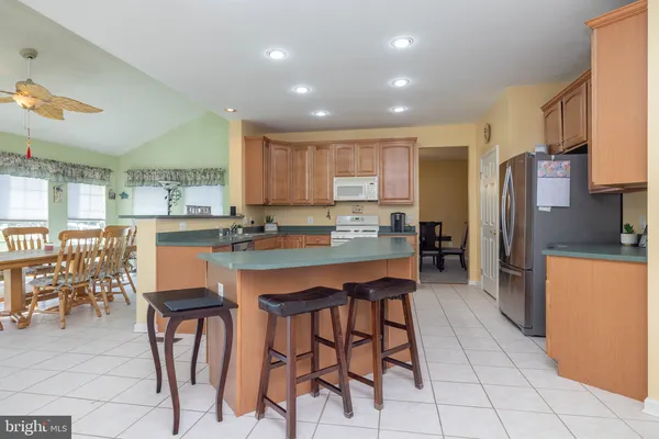 a kitchen with stainless steel appliances kitchen island granite countertop a refrigerator and cabinets