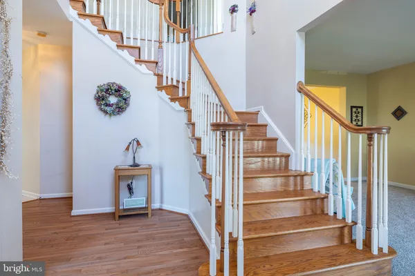 a view of entryway and hall with wooden floor