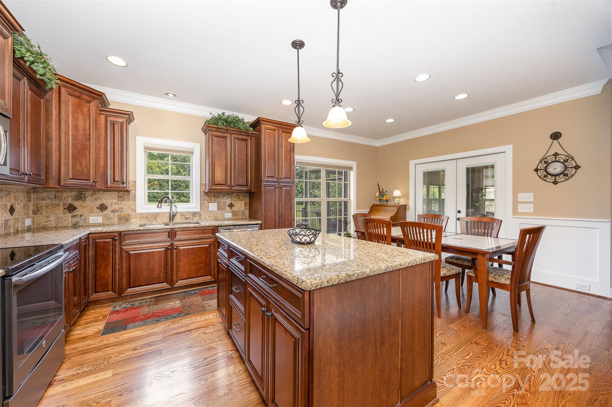 375 Pebblestone Court Lexington, NC 27295 - Photo 11 of 34 a kitchen with stainless steel appliances granite countertop a kitchen island a stove a sink a dining table and chairs with wooden floor
