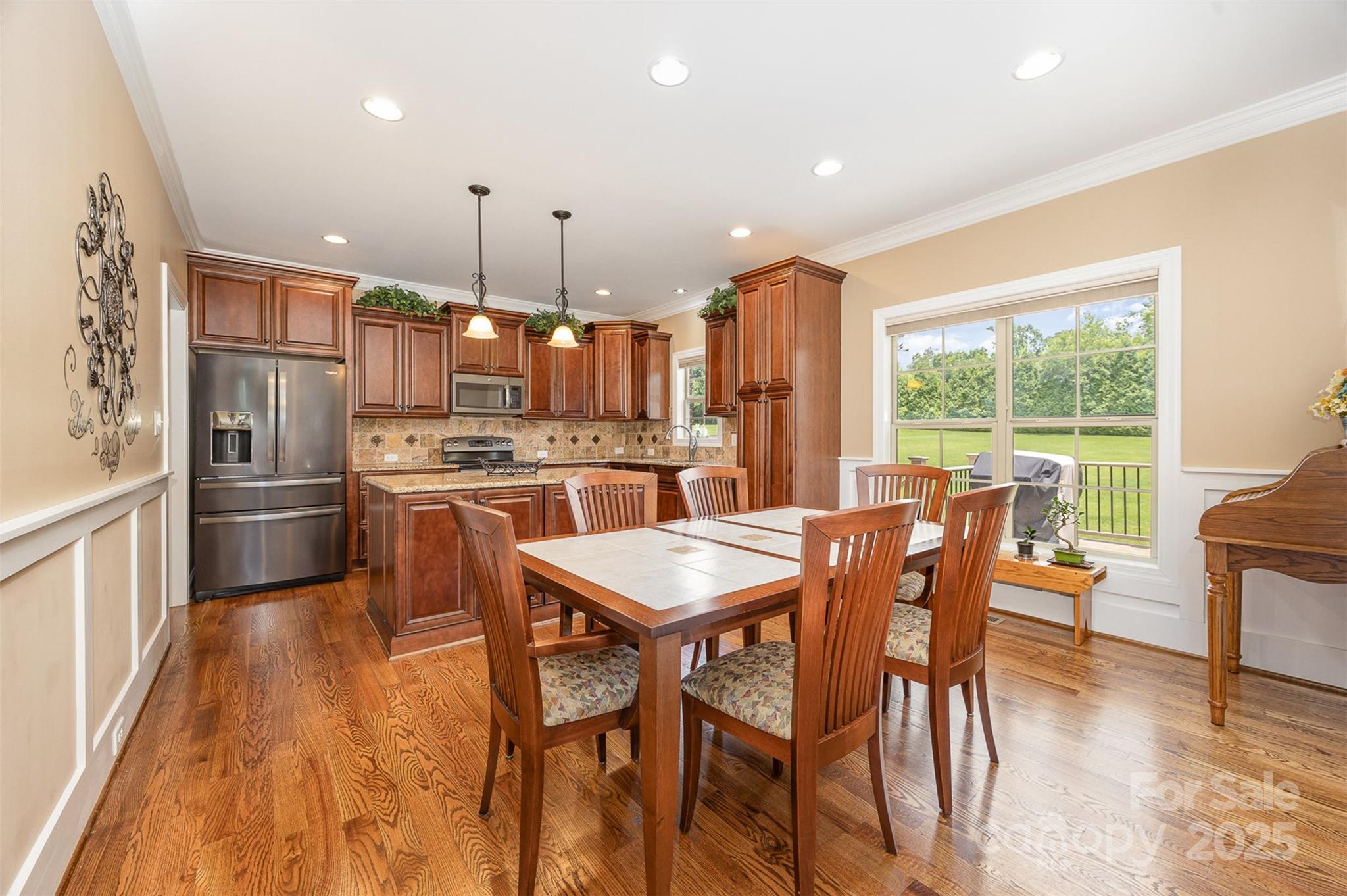 375 Pebblestone Court Lexington, NC 27295 - Photo 13 of 34 a kitchen with stainless steel appliances granite countertop a stove a refrigerator a kitchen island a dining table and chairs with wooden floor
