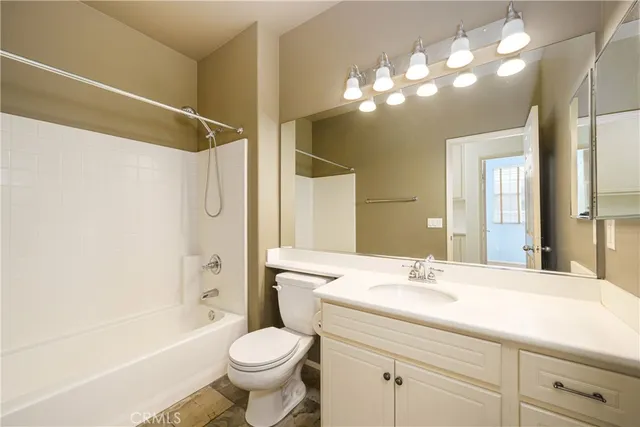 a bathroom with a sink a toilet a mirror a bathtub and shower