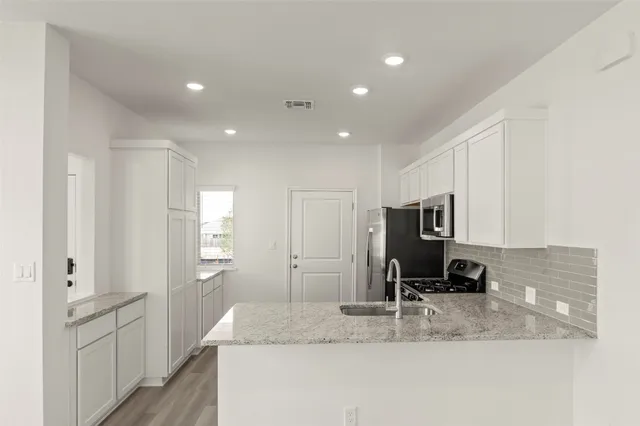 a kitchen with a refrigerator a microwave a sink and cabinets