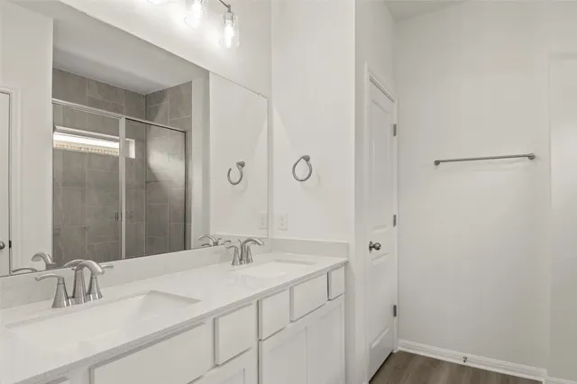 a bathroom with a granite countertop bathtub shower sink vanity and toilet