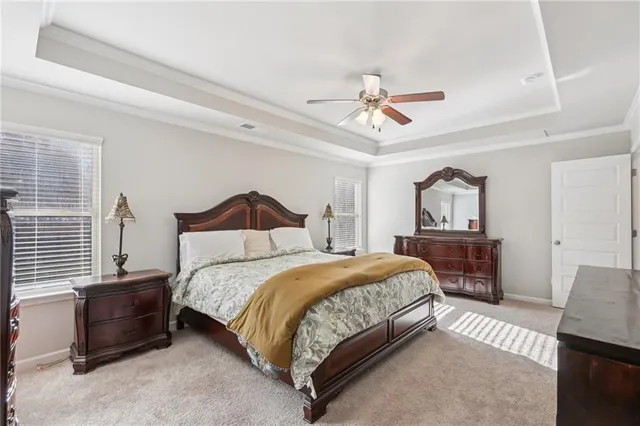 a bedroom with a large bed and a chandelier fan