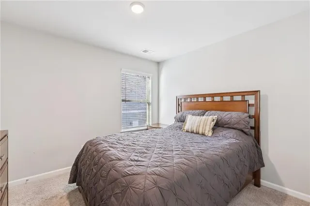 a bedroom with a large bed and a window