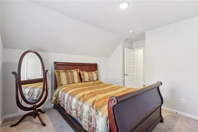 a bedroom with a bed a mirror and a window