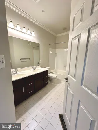 a spacious bathroom with a double vanity sink a mirror and a bathtub