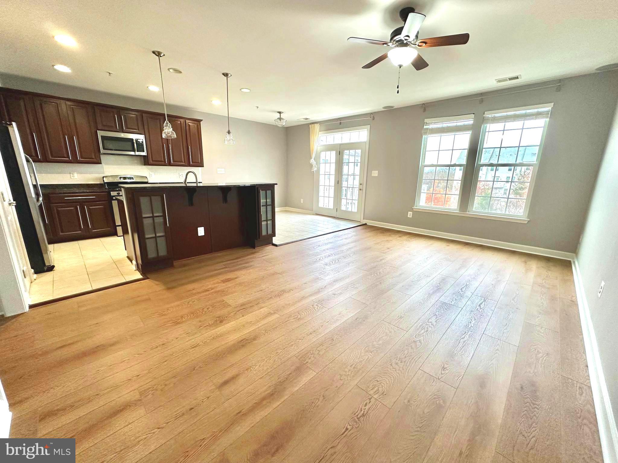 3606 Holborn Place Frederick, MD 21704 - Photo 3 of 30 a open kitchen with stainless steel appliances granite countertop a sink dishwasher a stove and a refrigerator with wooden floor