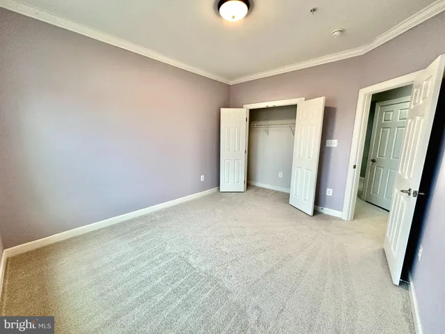 an empty room with closet and mirror