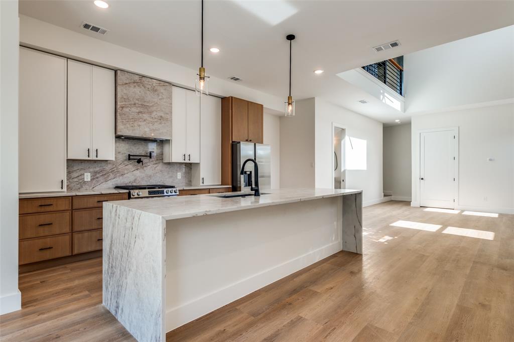 2424 Jeffries Street Dallas, TX 75215 - Photo 14 of 28 Kitchen with decorative light fixtures, light stone counters, backsplash, recessed lighting, and light wood-style flooring