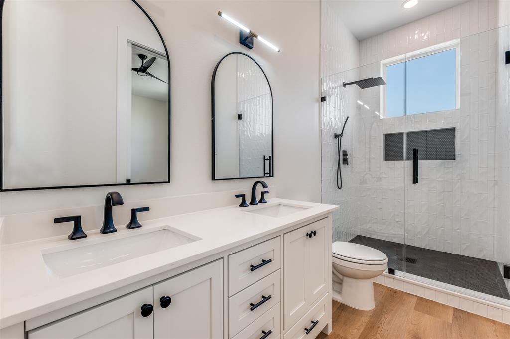 2424 Jeffries Street Dallas, TX 75215 - Photo 24 of 28 Full bath featuring double vanity, a stall shower, and light wood-style floors