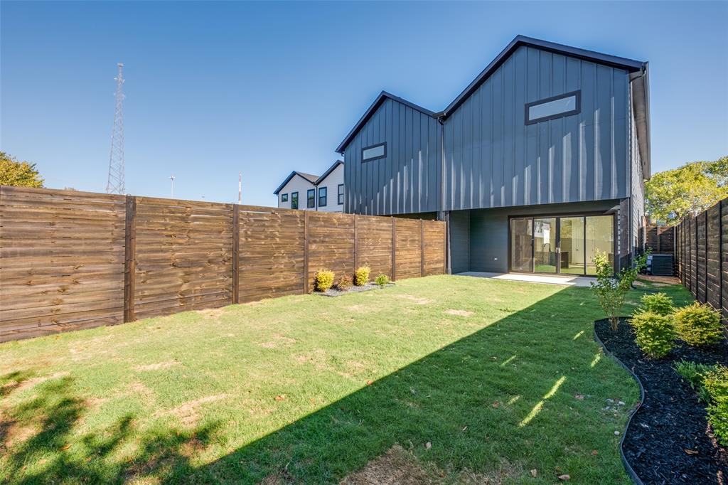 2424 Jeffries Street Dallas, TX 75215 - Photo 27 of 28 Back of property featuring board and batten siding, a fenced backyard, and a patio
