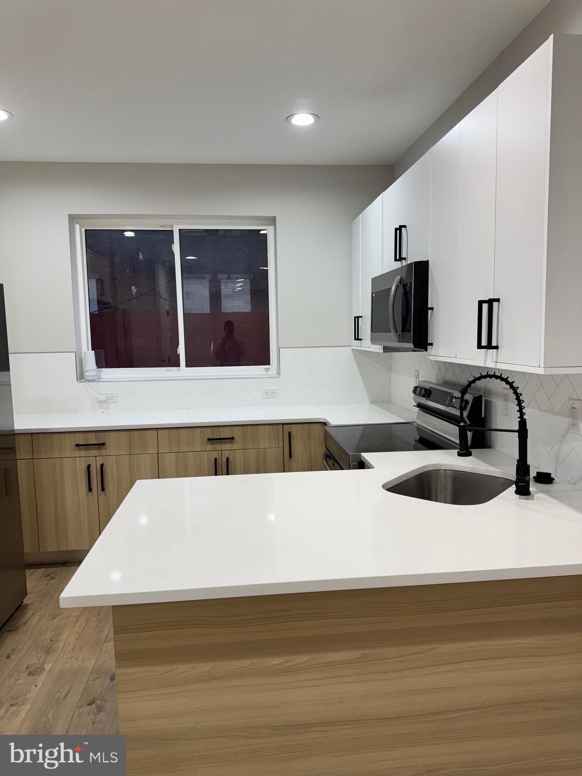 2256 North 9th Street, Unit 1 Philadelphia, PA 19133 - Photo 5 of 29 a kitchen with a sink and a stove top oven with wooden floor