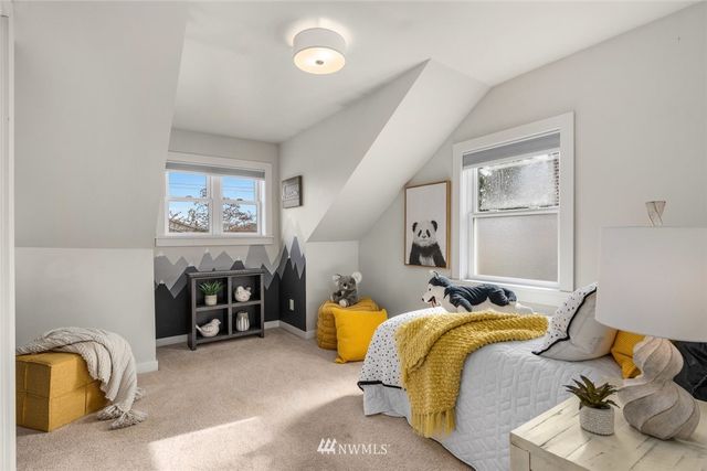 a bedroom with two beds and painting on the wall