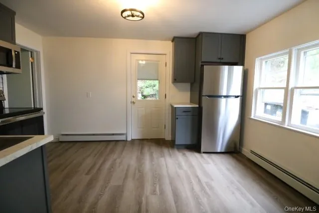 a view of kitchen with wooden floor electronic appliances and windows