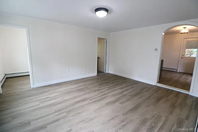 an empty room with wooden floor and mirror