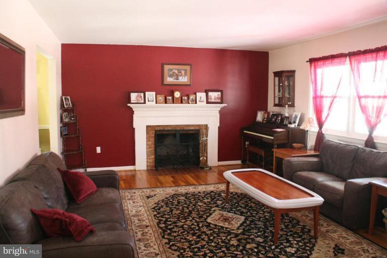 5705 Ashfield Road Alexandria, VA 22315 - Photo 5 of 28 a living room with furniture a rug and a fireplace