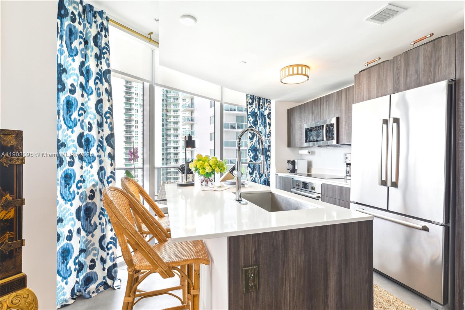 488 Northeast 18th Street, Unit 2301 Miami, FL 33132 - Photo 15 of 43 a kitchen with stainless steel appliances a refrigerator a table and chairs
