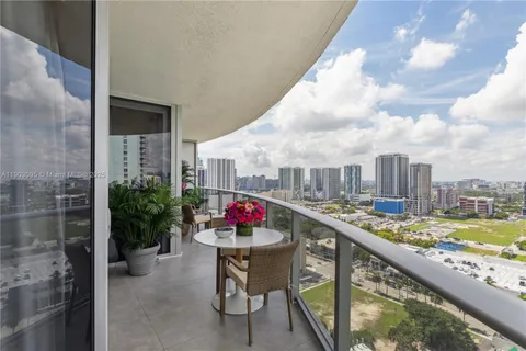 a view of a balcony with dining table and chairs