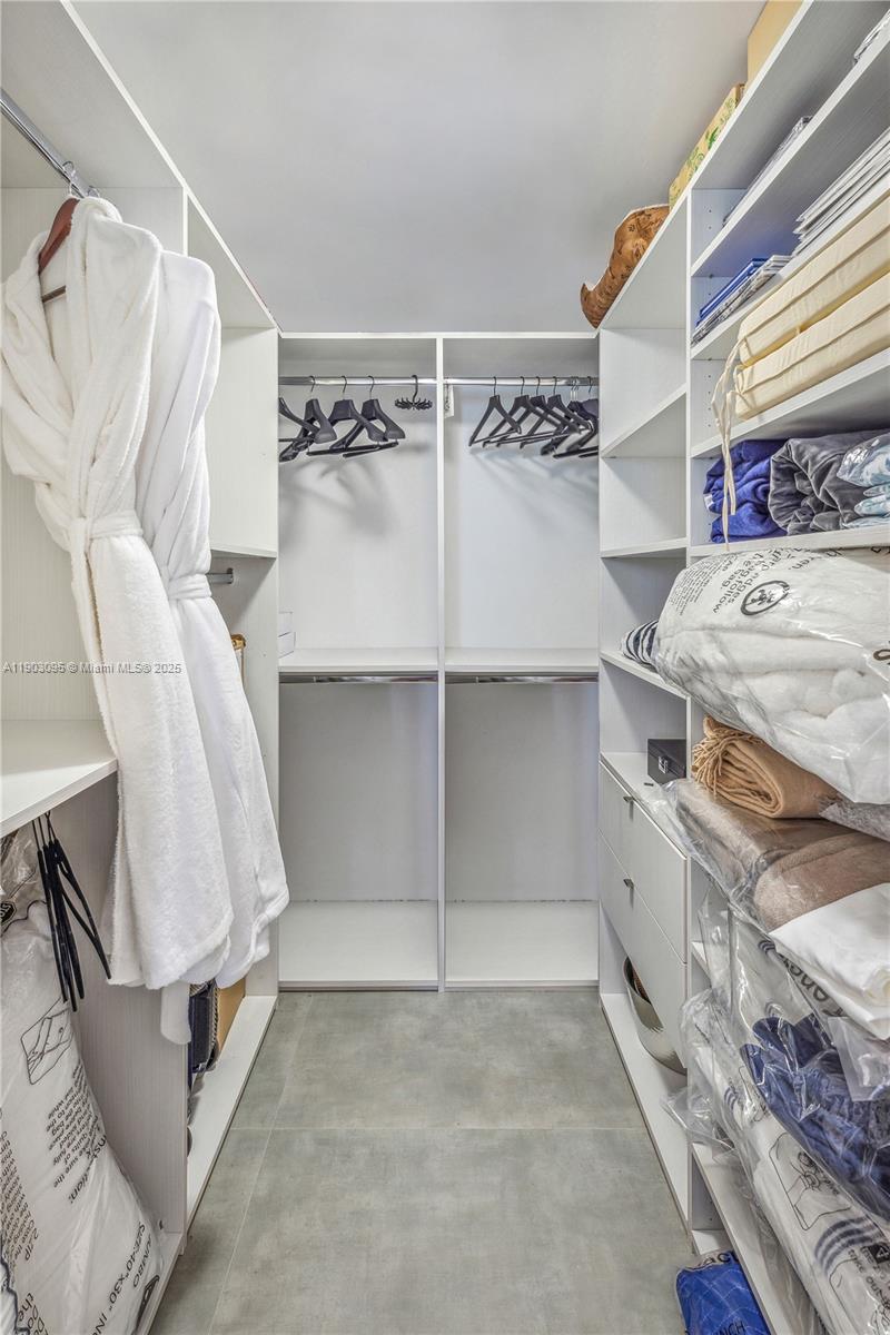 488 Northeast 18th Street, Unit 2301 Miami, FL 33132 - Photo 7 of 43 a view of walk in closet with clothes and shoes